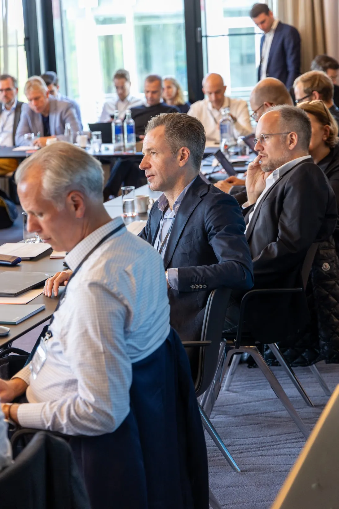 Männer in Anzügen hören Konferenz zu
