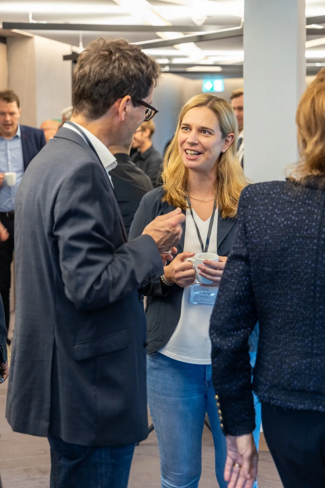 Geschäftsmänner und Frauen im Anzug / Business Casual führen ein Gespräch
