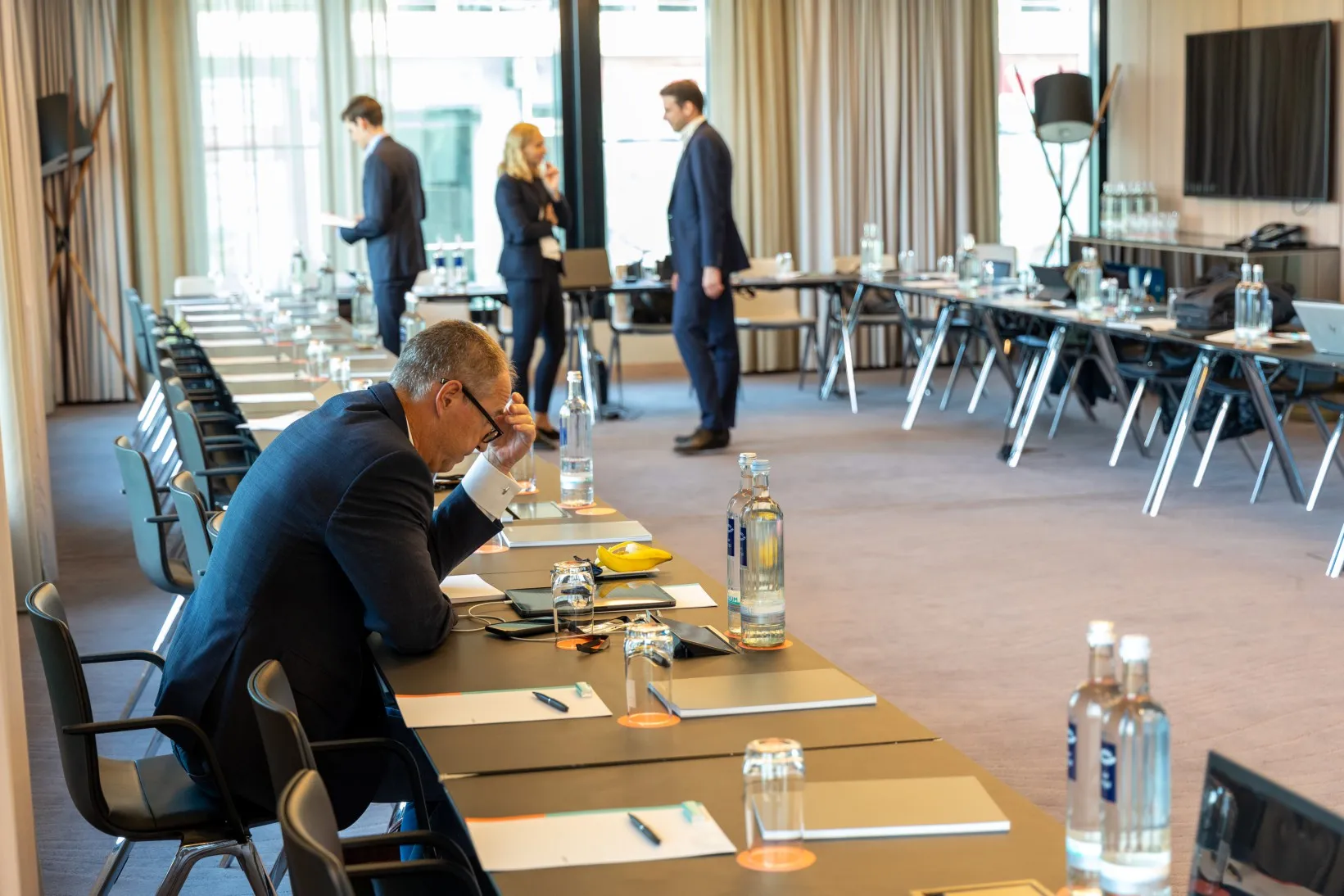 Menschen setzen sich an ihren platz in einem Meetingraum