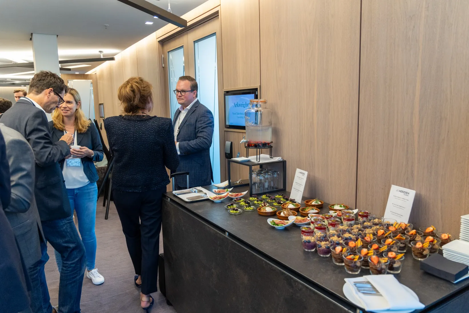 Geschäftsleute stehen vor einem Buffet