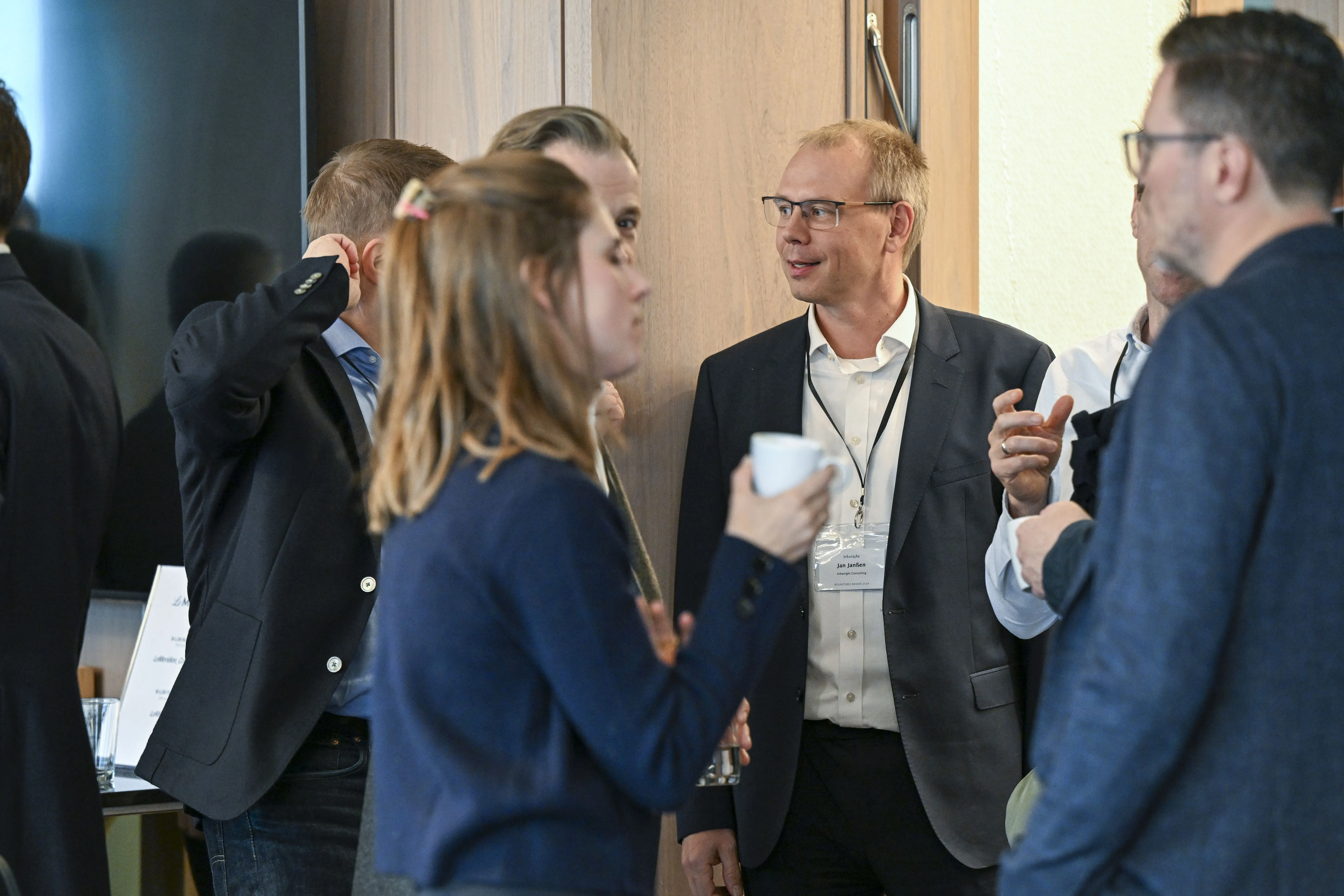 Gruppe von Geschäftsleuten in Anzügen unterhalten sich