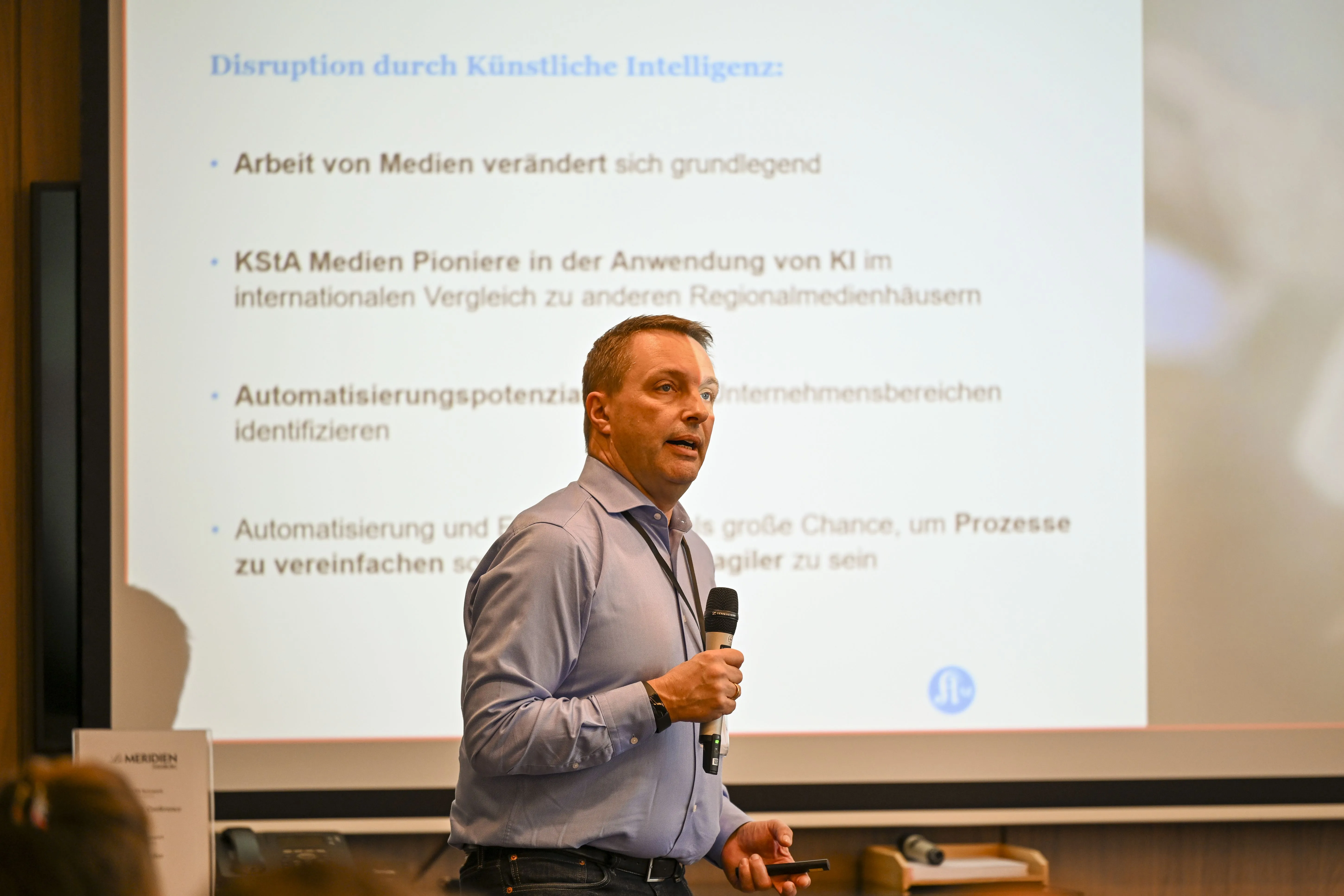 Mann in hellem Hemd spricht in ein Mikrofon