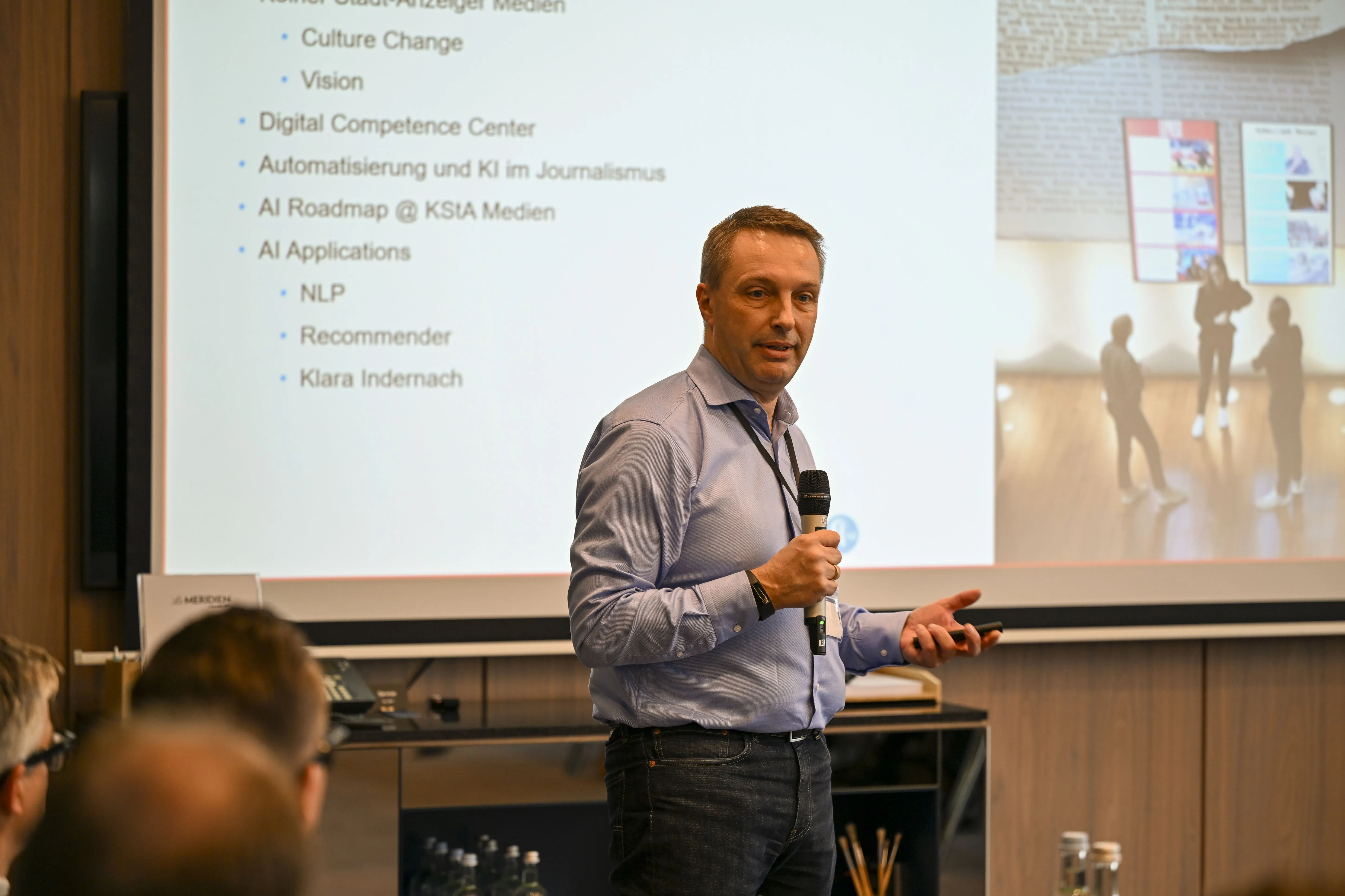 Mann in hellem Hemd spricht in ein Mikrofon