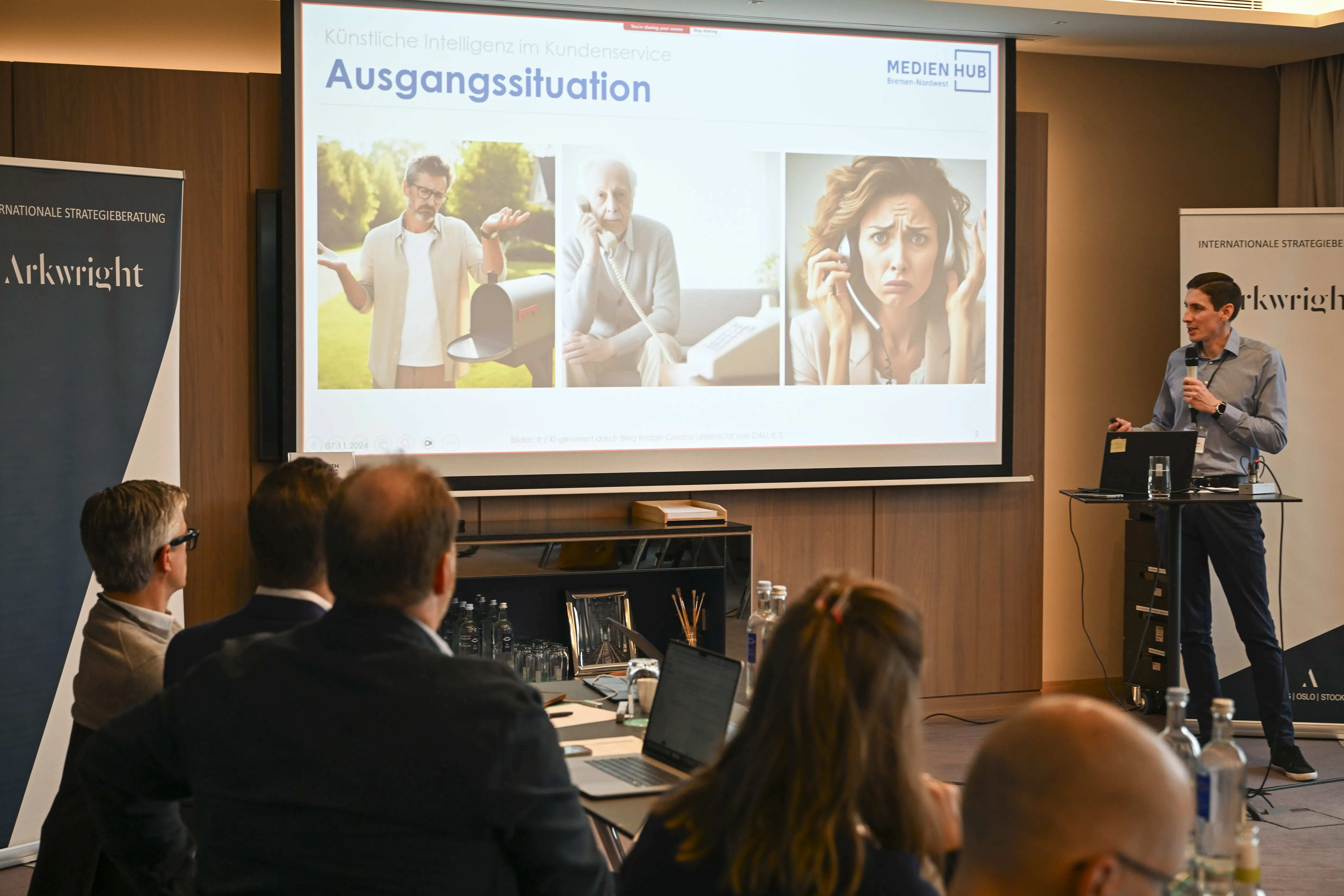 Ansicht eines Meetingraumes, Fokus ist auf den Vortragsfolien der Präsentation