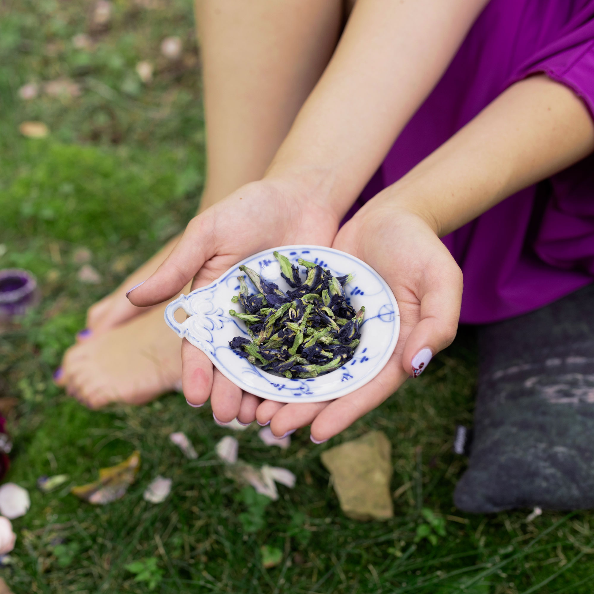 Girl holding white bowl with CreativiTea leaves