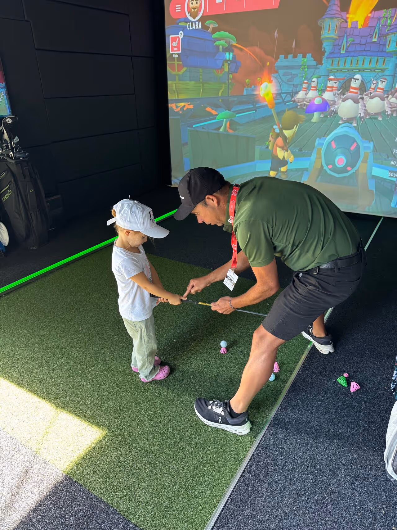 A child learning to golf inside of a Mobile Golf Simulator