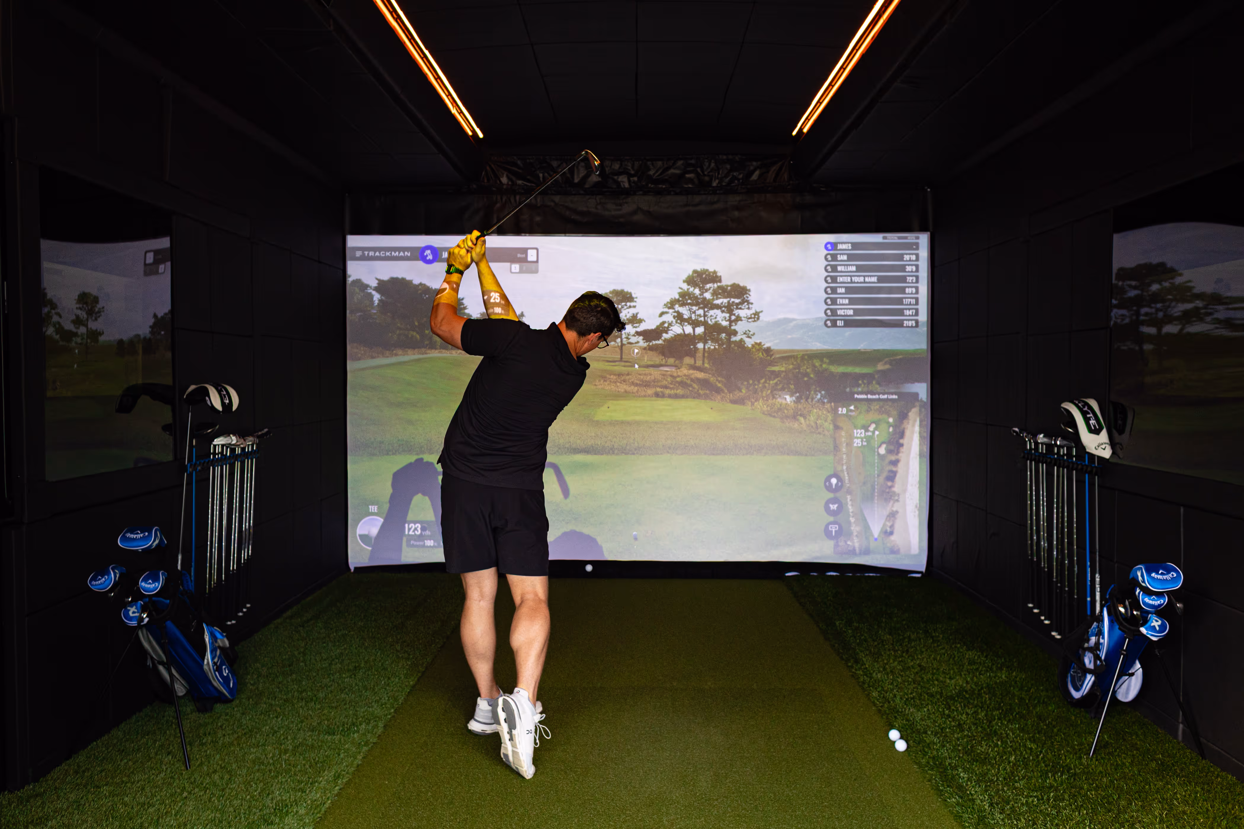 Mobile golf simulator set up at an outdoor event. Indoor pop-up golf simulator set up at a venue. 
