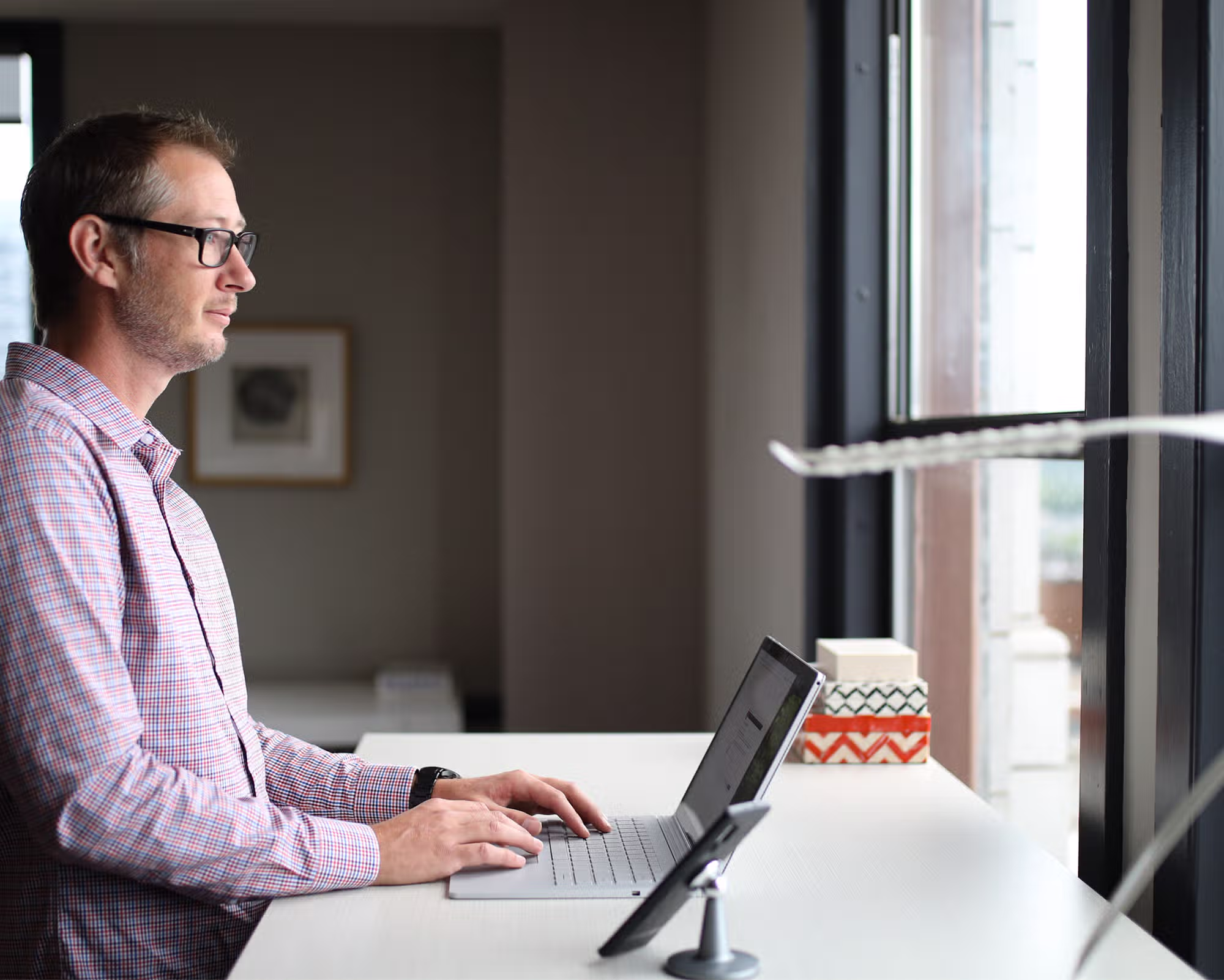 A man working at a deck on a laptop computer.