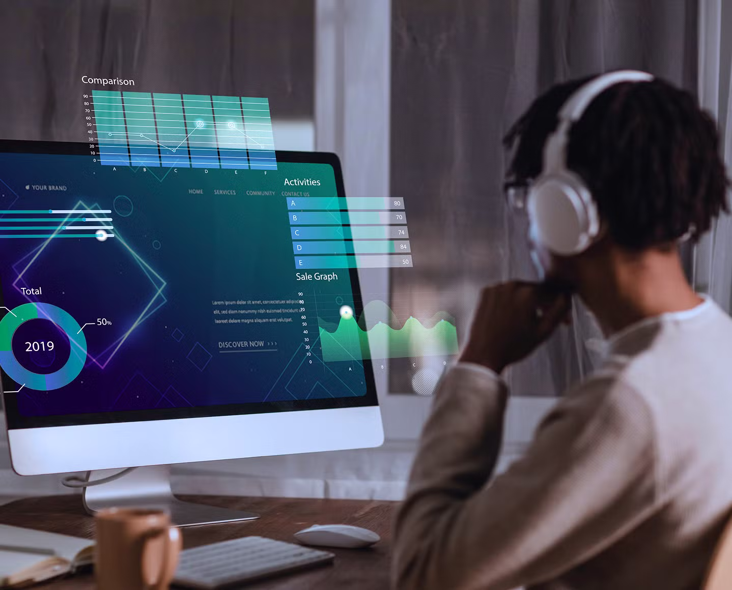 A person wearing white headphones sits at a desk, looking at a large desktop monitor displaying futuristic data visualizations, including graphs, charts, and activity metrics.