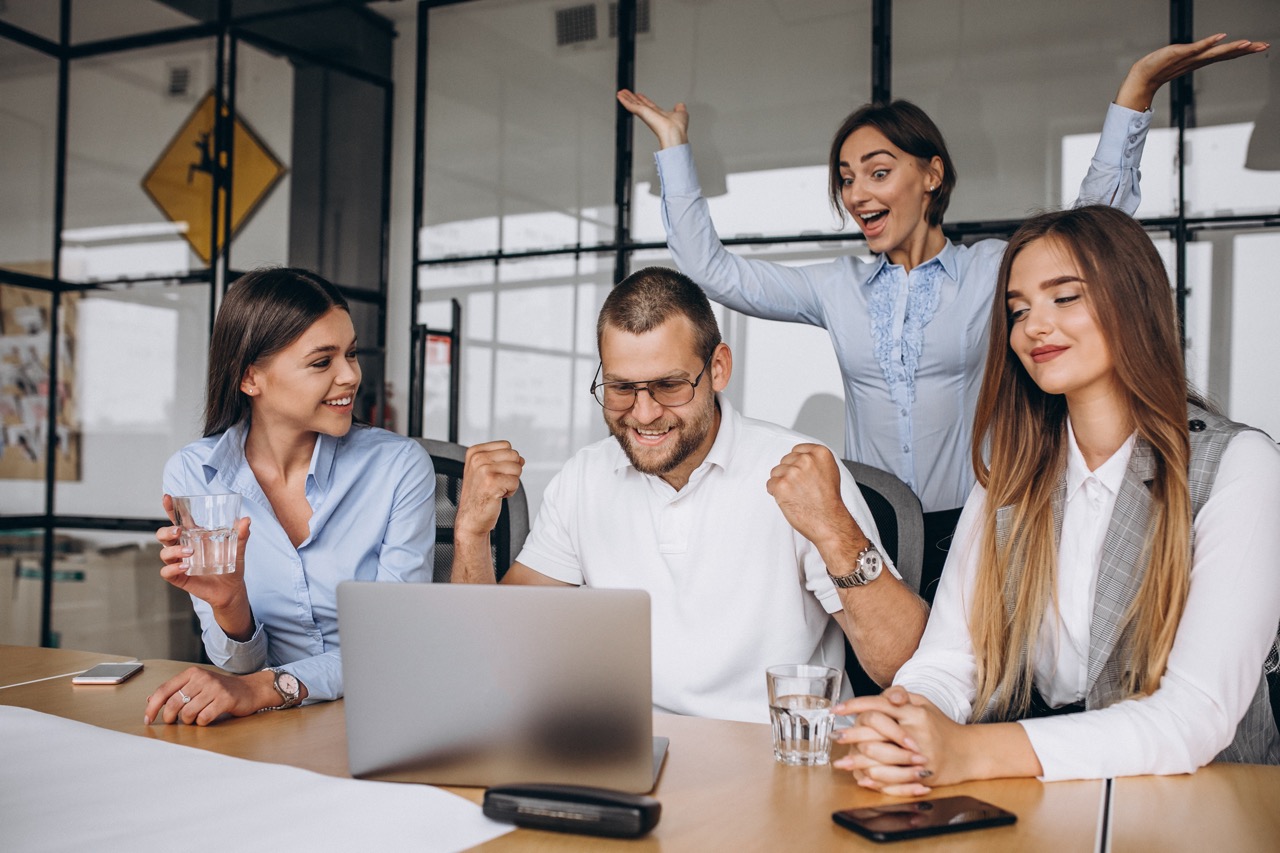 Woman smiling behind laptop, making digital work instructions