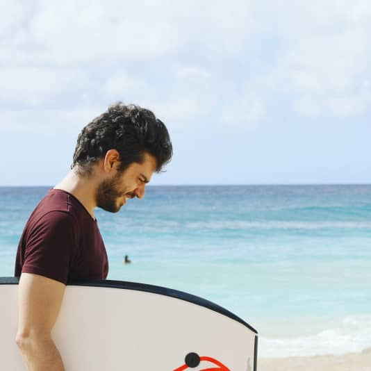 a man on the beach with his boogie board