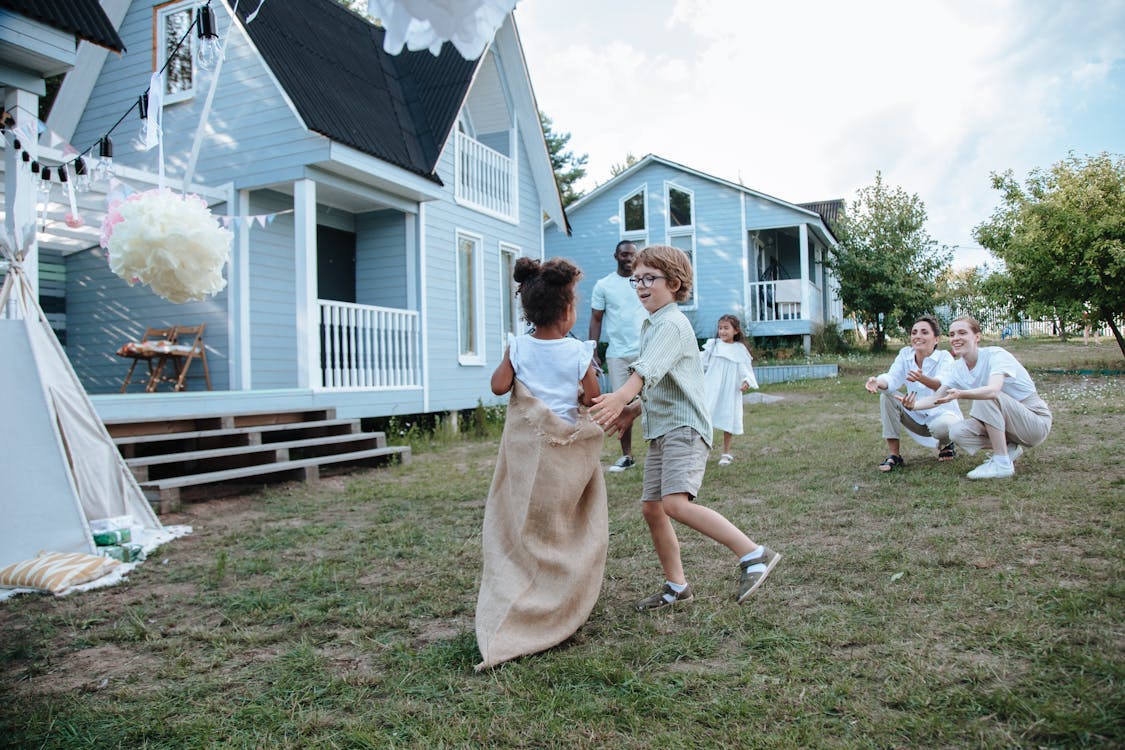 Free People Playing Sack Race on Green Grass Stock Photo