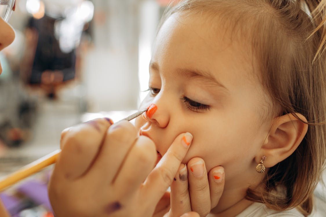 Free Close up of Hands Painting Girl Face Stock Photo