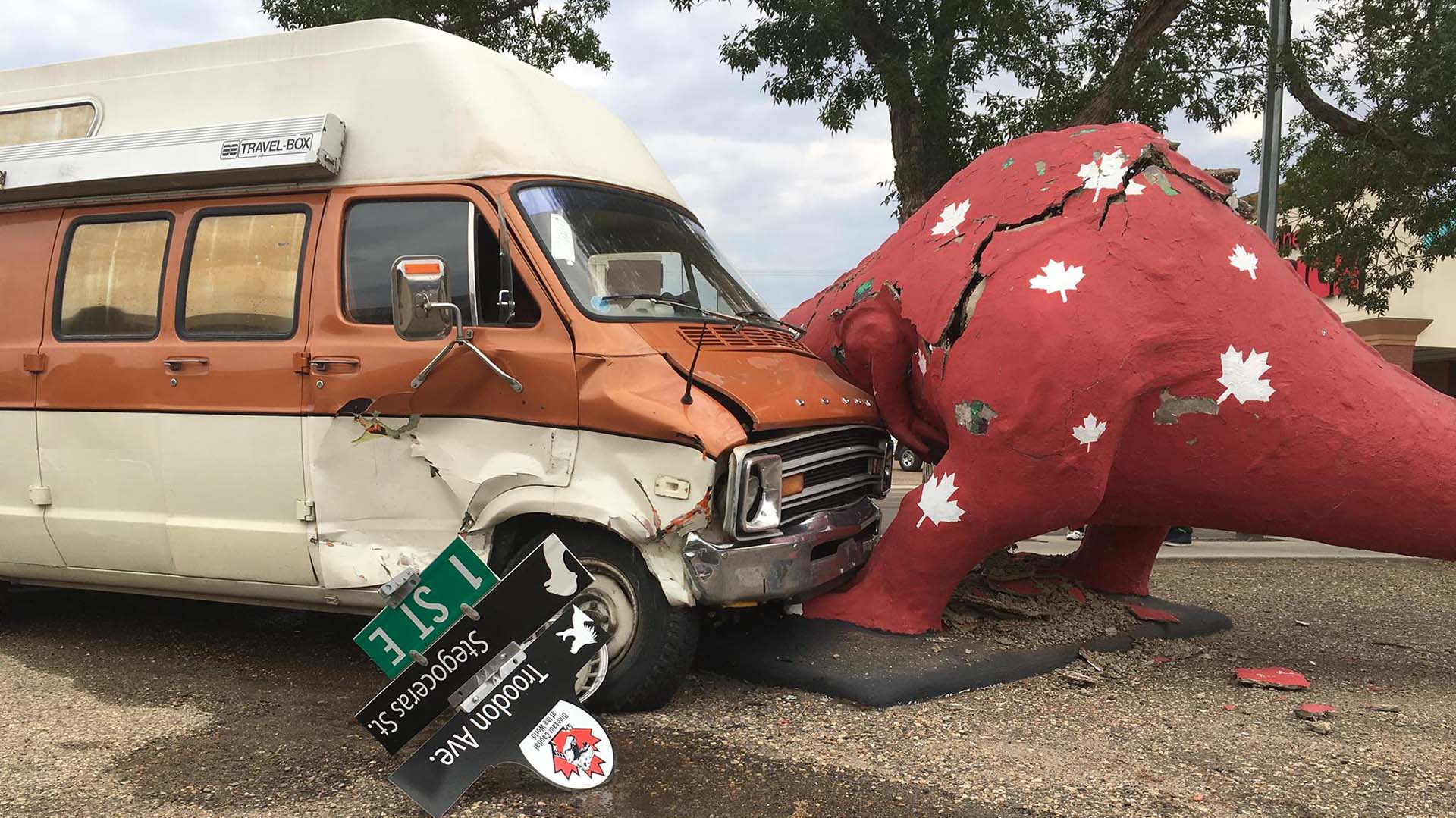 A image of a dinosaur that is in contact with a van