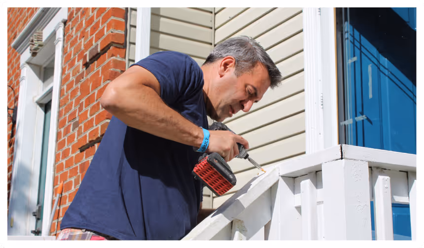 image of a person drilling a hole as a part of community service at towerhill church