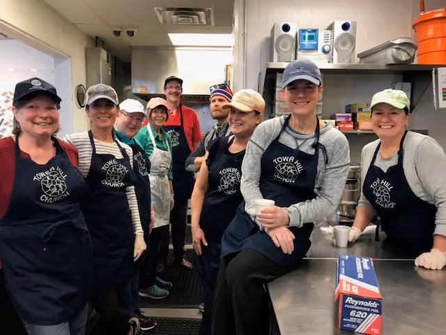 a group of volunteers posing for a photo in a kitchen at towerhill church