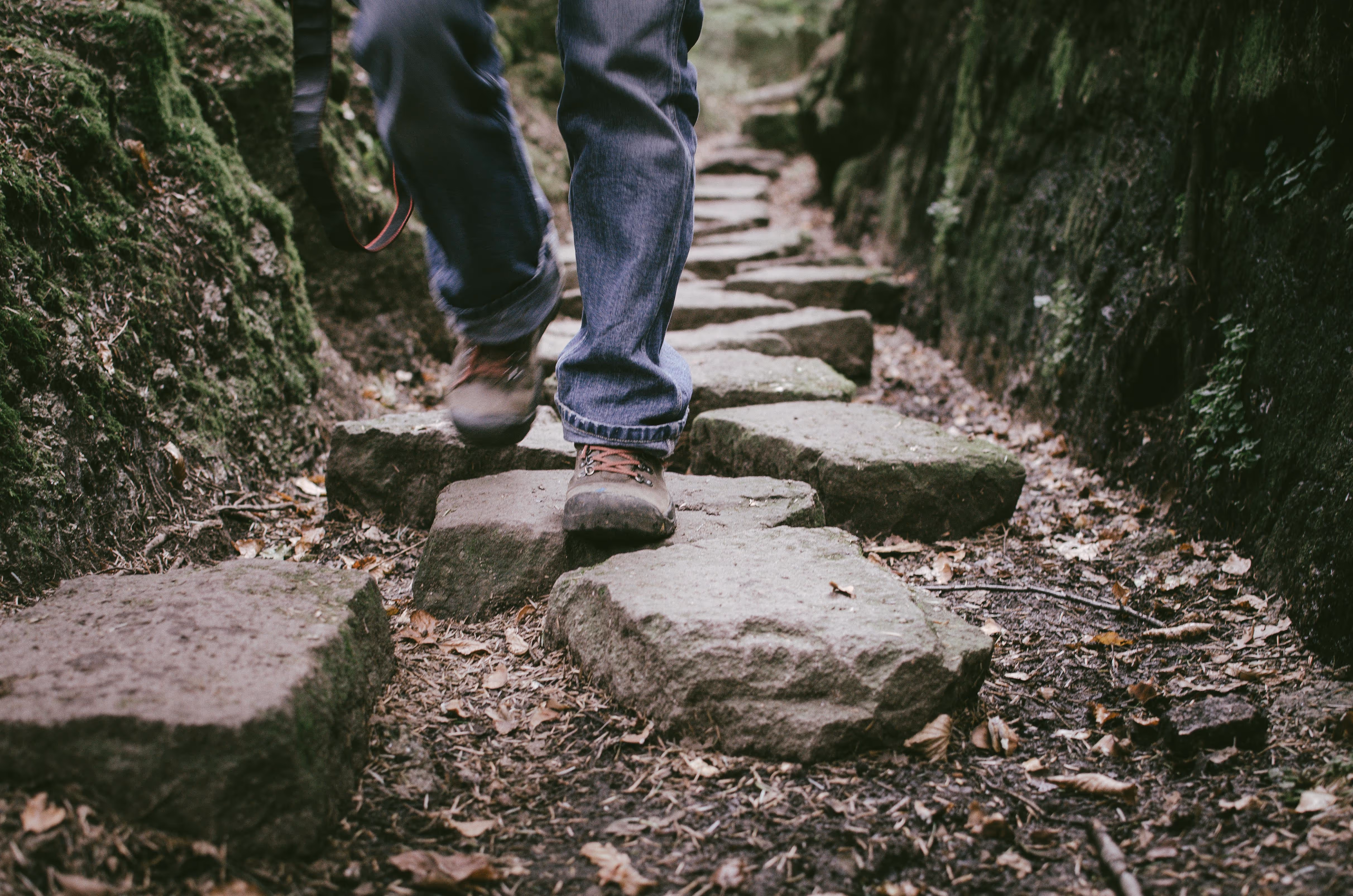 a stock image of a person's legs while he walks on stones