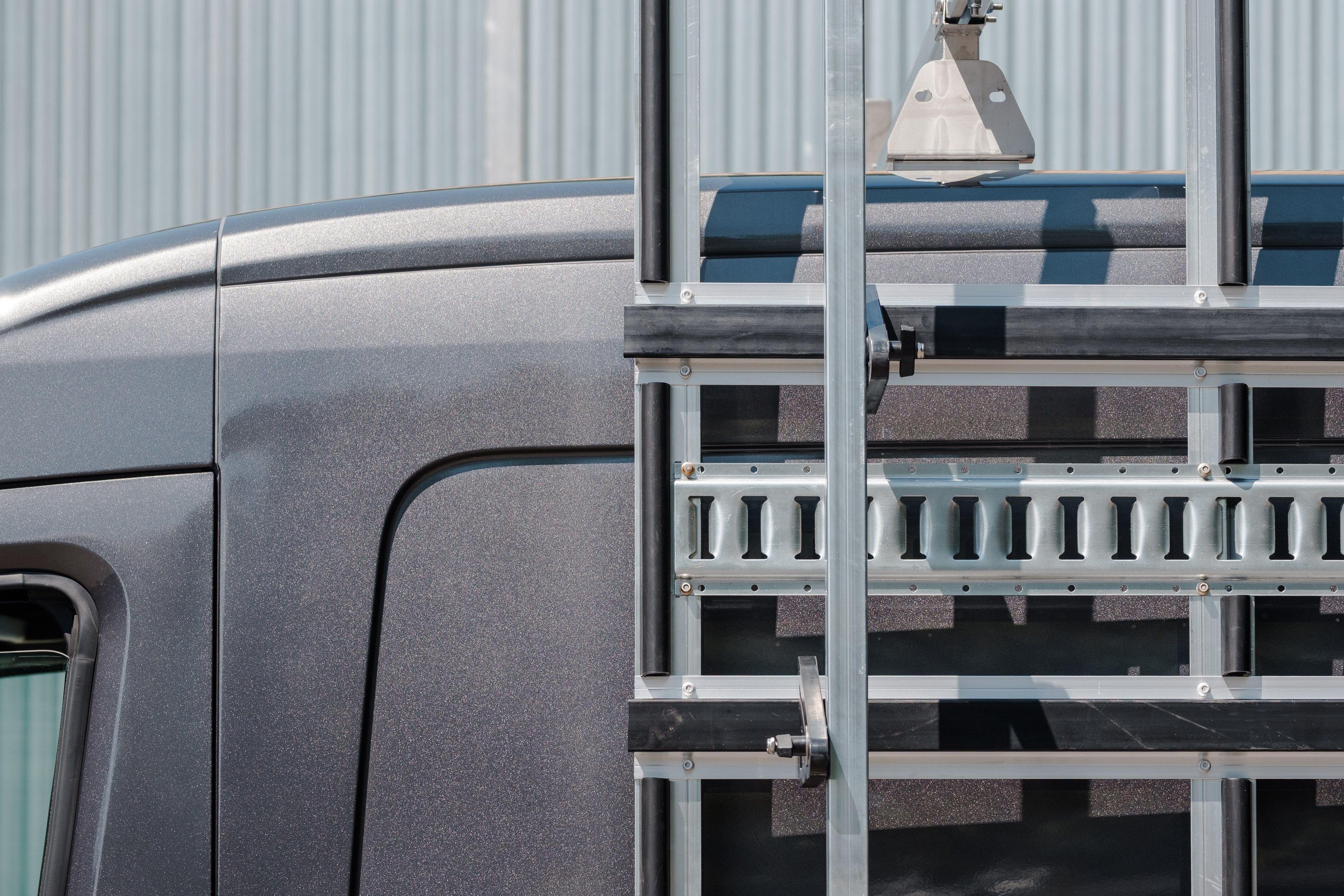 Close-up of aluminum rack framing with huck-bolt fasteners securing the vertical posts.