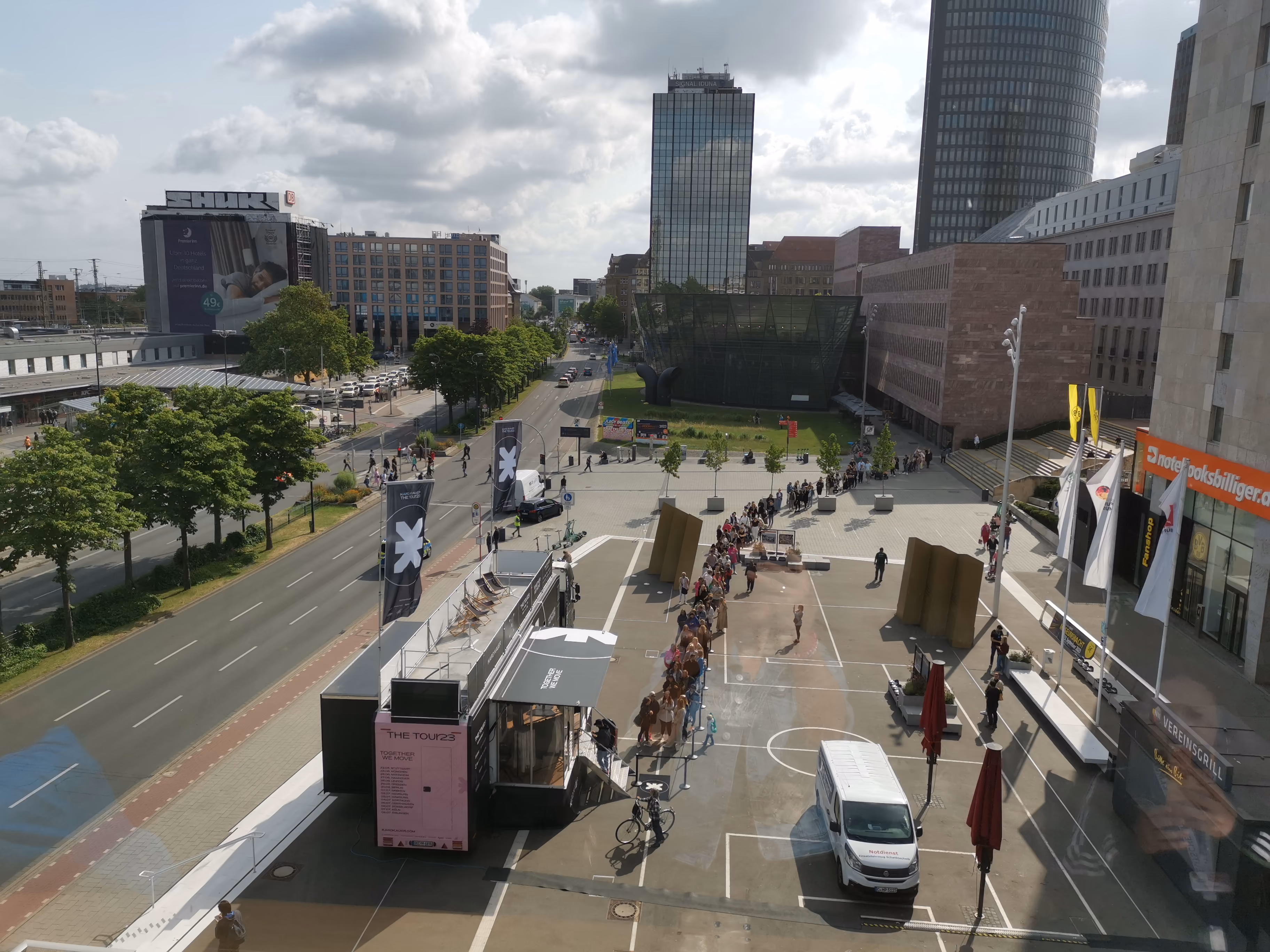 Pop-up Store in urban plaza with crowds gathered outdoors in city center.