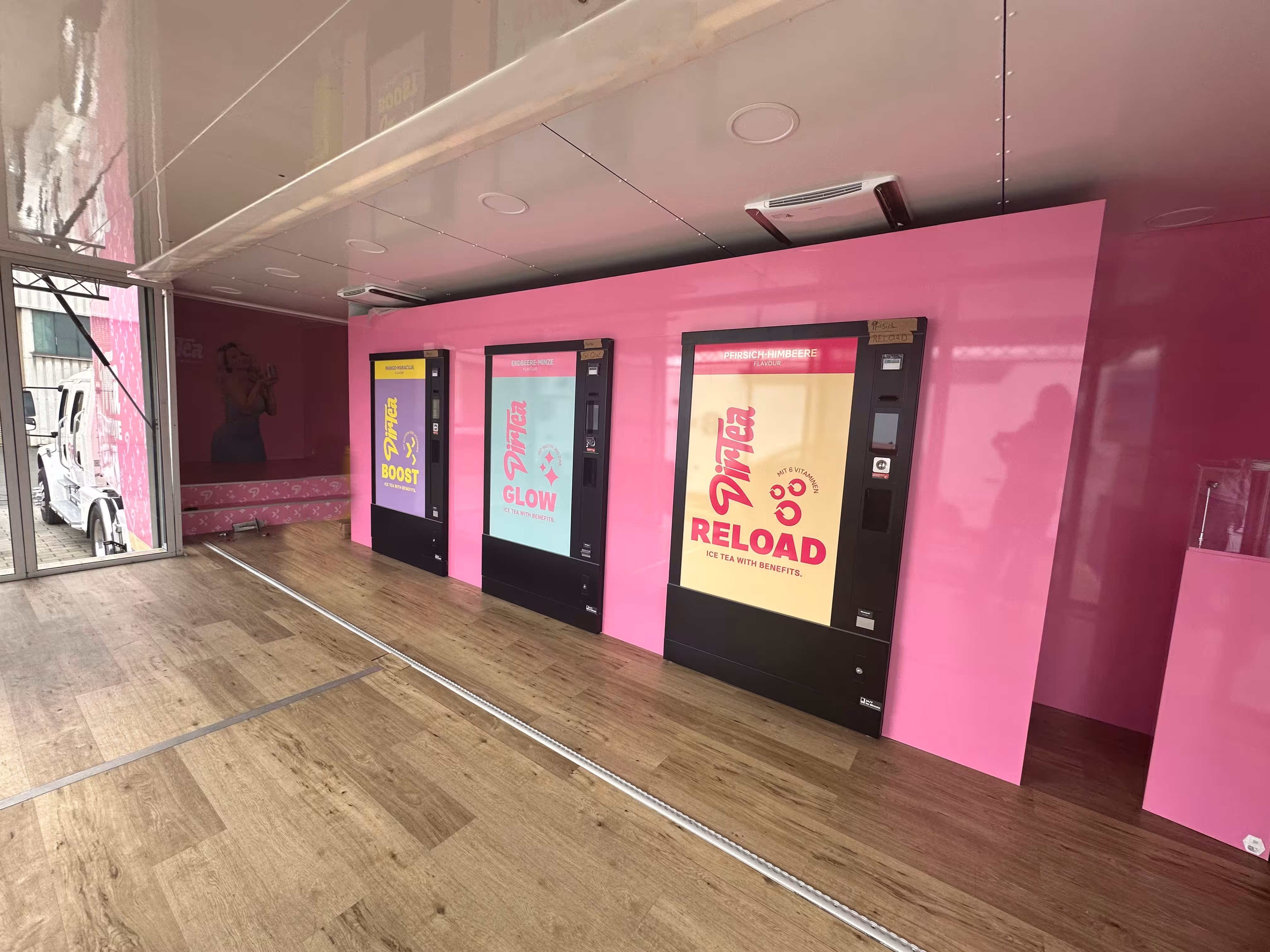 Pinker Promotiontruck Innenraum mit Verkaufsautomaten und modernem Design.