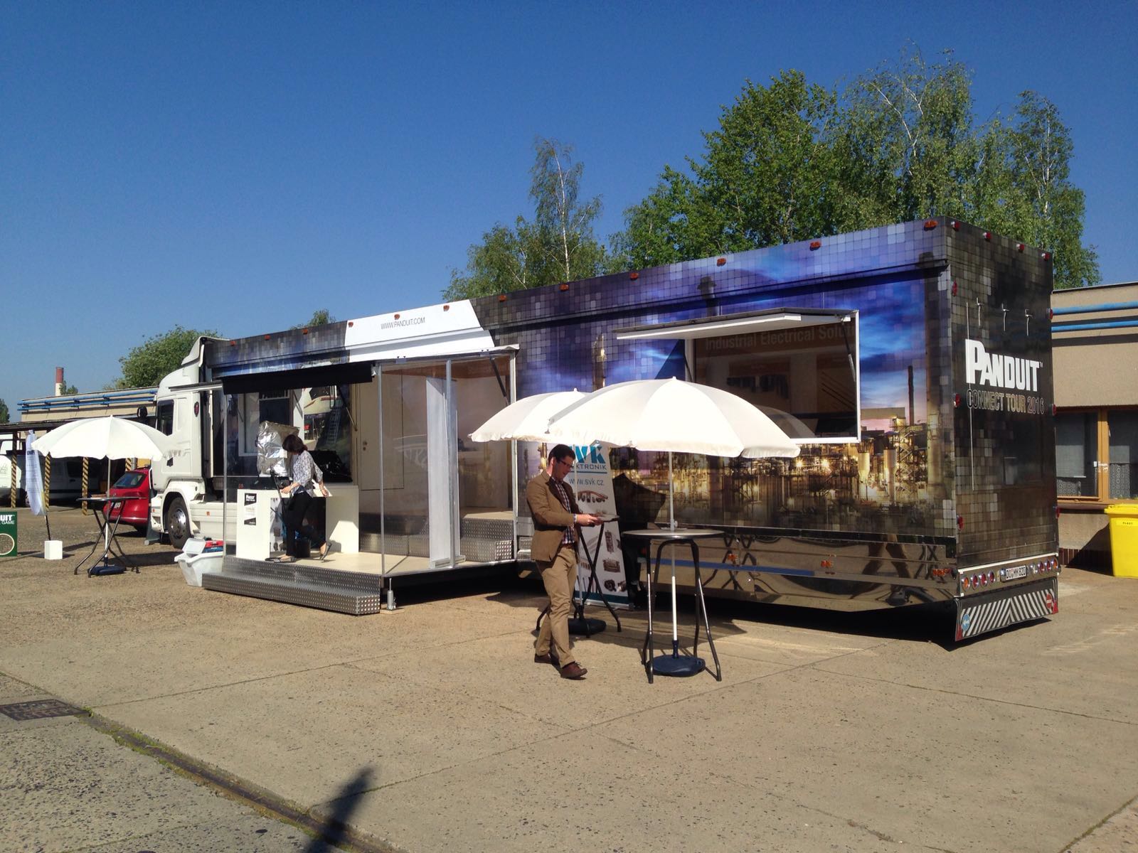 Ein großer Showtruck mit dem Panduit Logo auf der Rückseite steht auf einem sonnigen Platz. Die Türen sind geöffnet, ein Eingangsbereich ausgefahren.