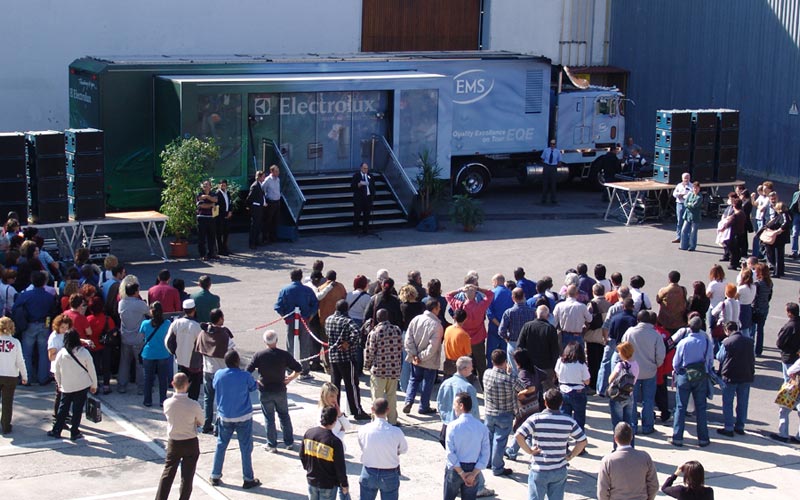Eine Menschenmenge versammelt sich vor einem blauen Electrolux-Showtruck mit blau-grün gebrandeten Sattelauflieger. 