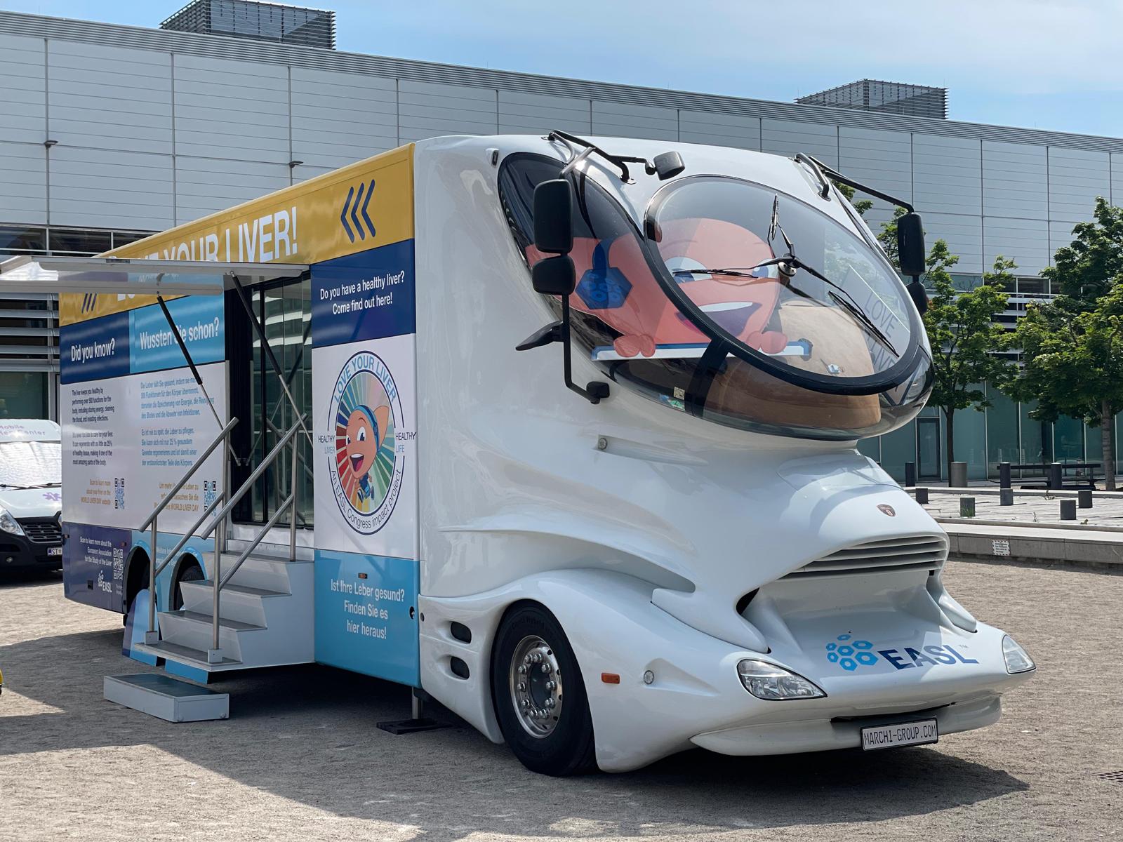 Futuristischer Design-Truck von EASL steht mit offener Tür auf einem sonnigen Platz. Die Seiten sind mit Informationen zur Leber beschriftet.