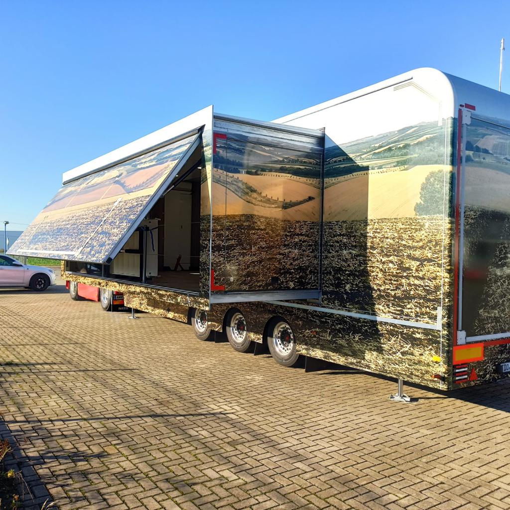 Moderner Showtruck mit ausfahrbaren Seitenwänden gebrandet mit landschaftlichen Bildern.