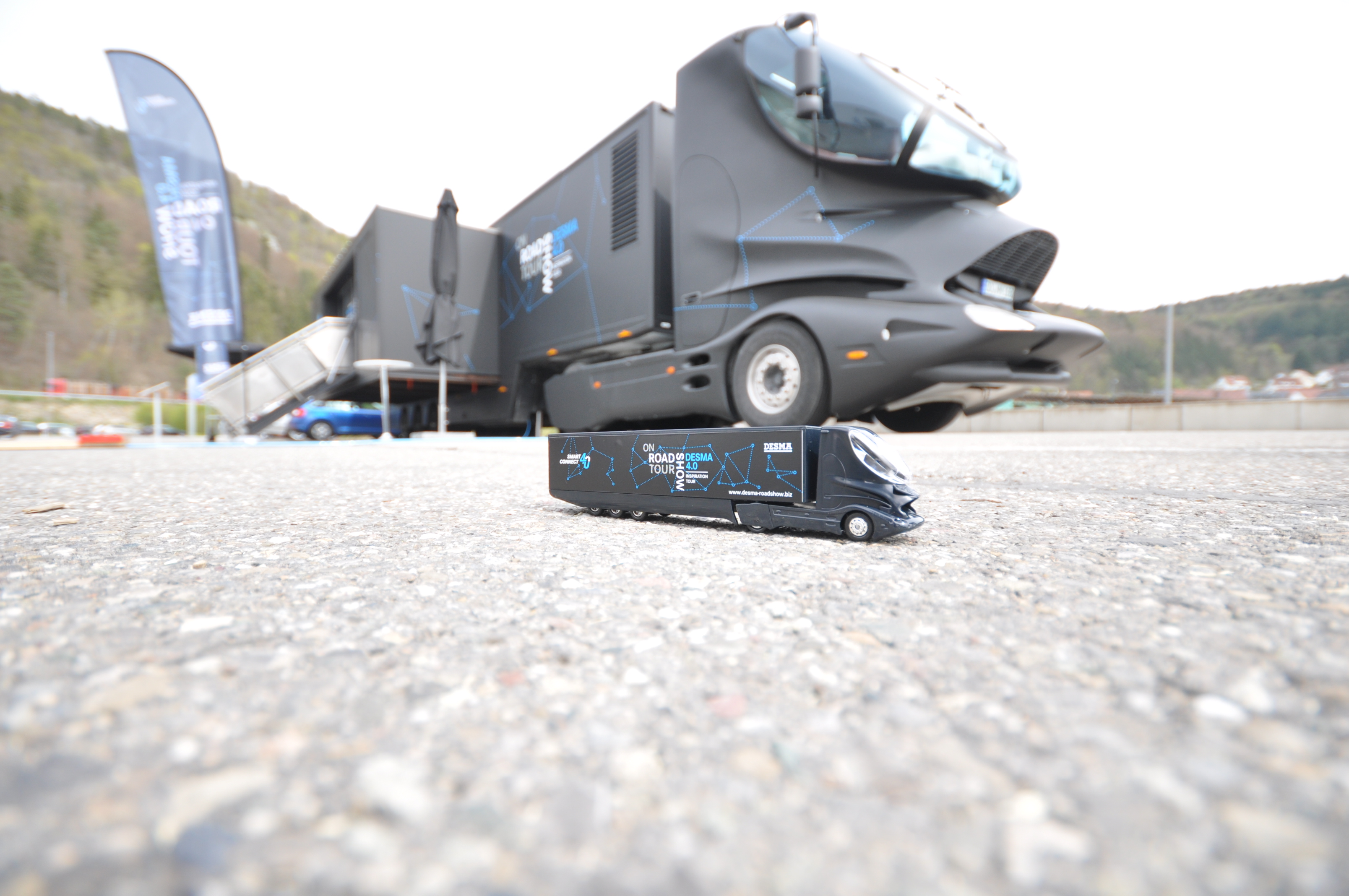 Miniatur Collani Design-Truck steht vor seinem Äquivalent in groß. 