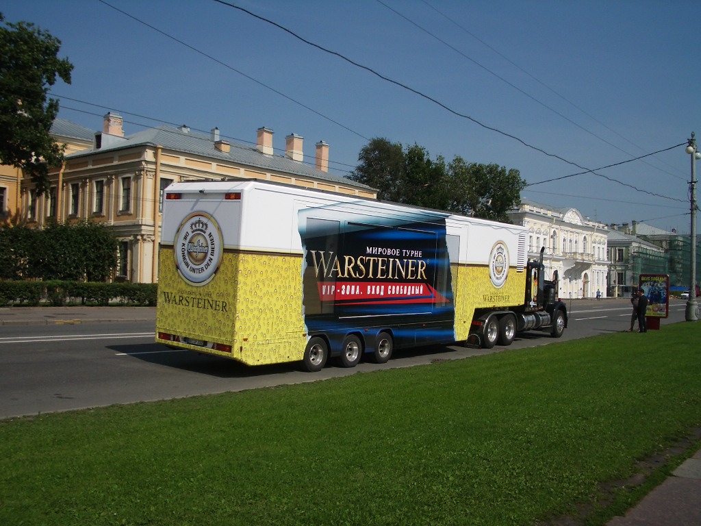 Warsteiner Showtruck mit gelb-weißer Lackierung auf einer Stadtstraße geparkt.