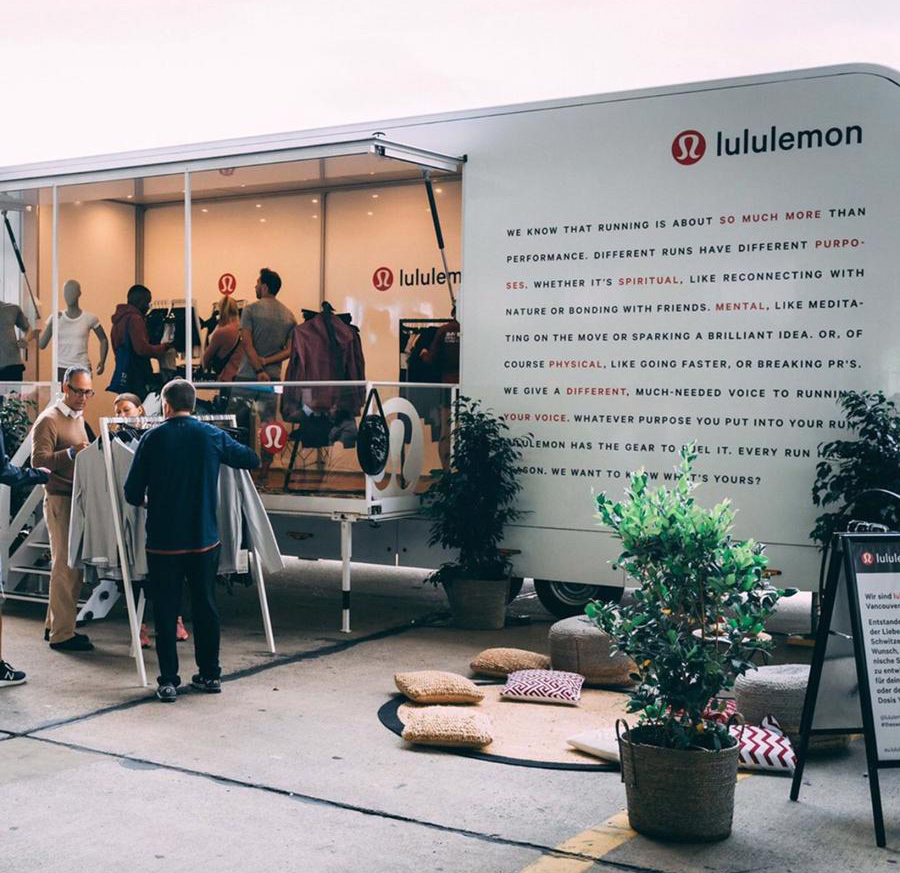 Lululemon Pop-up Store PKW-Anhänger mit Kunden, Sportbekleidung und inspirierendem Text über das Laufen.