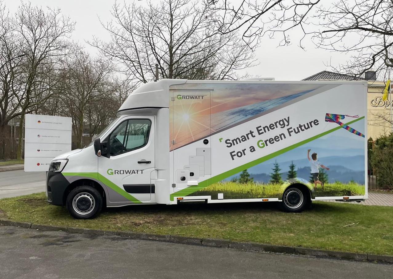Growatt Infomobil: Weißer Van mit Sonne- und Wind-Motiven foliert sowie Werbespruch "Smart Energy For a Green Future".