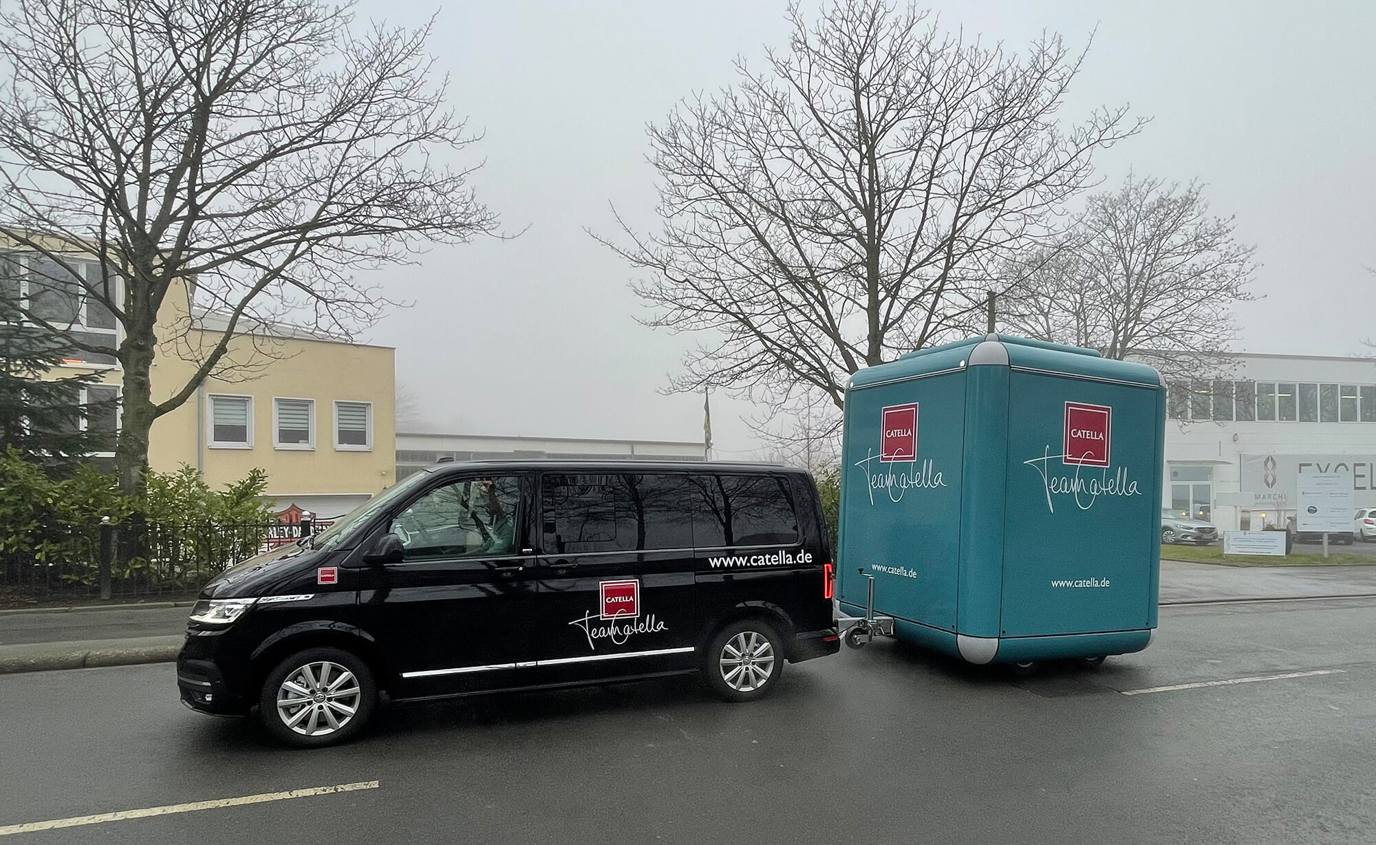 Schwarzer PKW zieht einen geschlossenen Marchi Cube Promotionanhänger.
