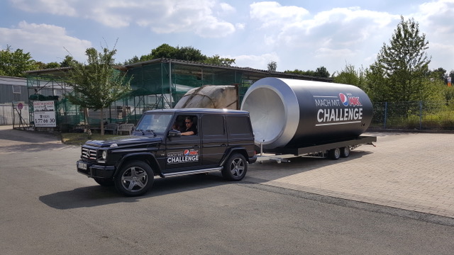 Giant Pepsi Max “Mach mit Challenge” can on a trailer, towed by a black branded off-road vehicle.