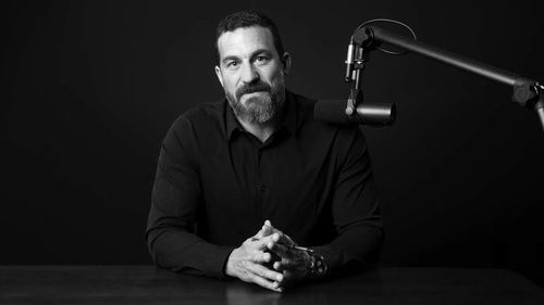Dr. Andrew Huberman speaking into a microphone