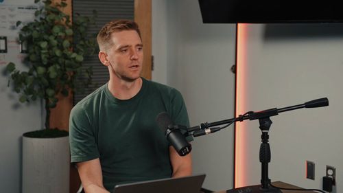 Ben Wilson, host of the How to Take Over the World podcast, speaking into a microphone.