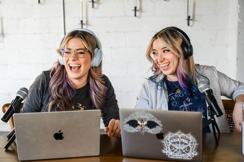 Fantasy Fangirls hosts, Nicole and Lexi, laugh while recording an episode of their podcast.