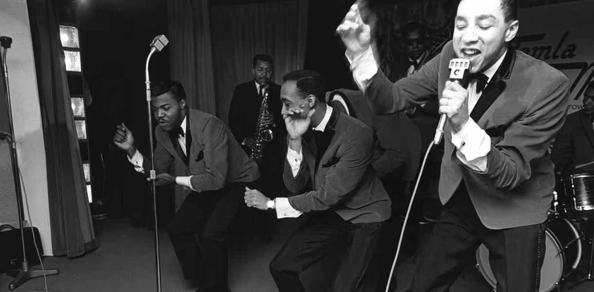 Smokey Robinson (right) performs onstage with the Miracles.