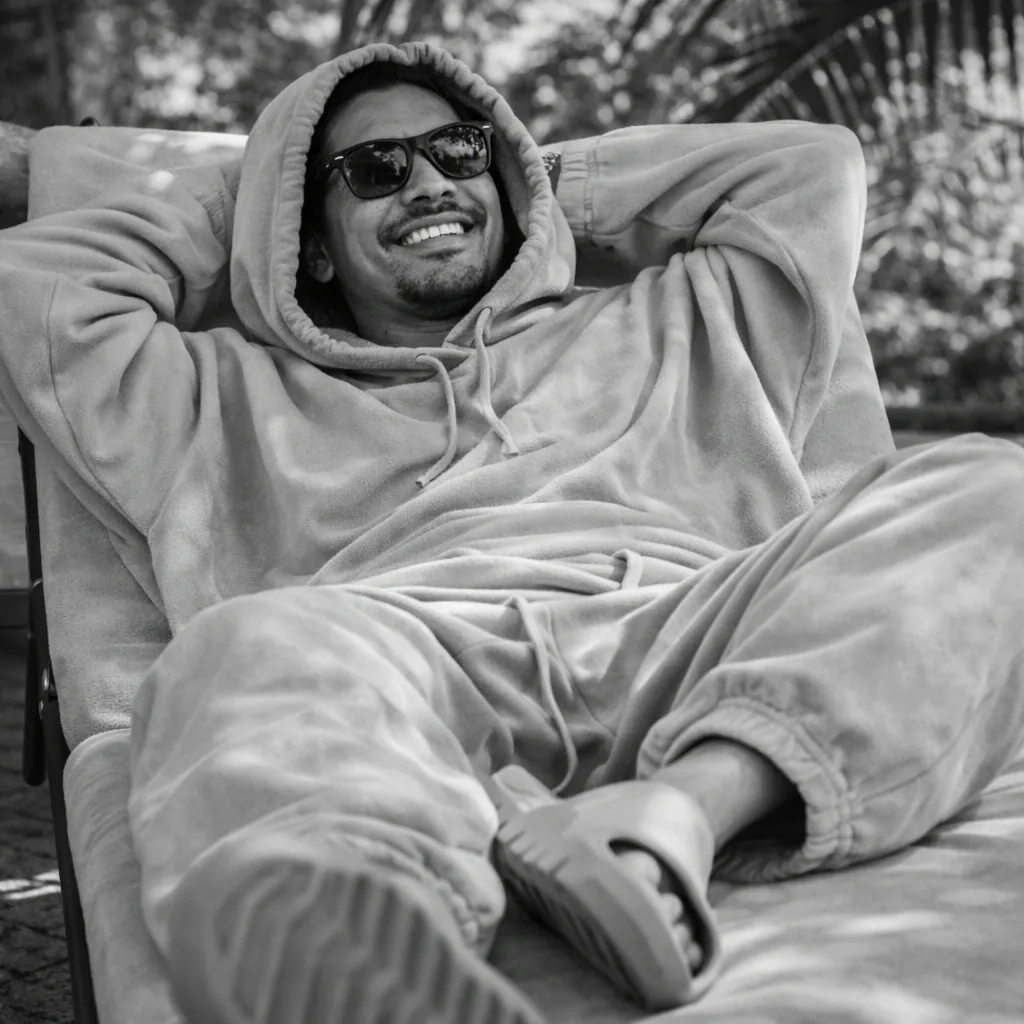 A man in a hooded fleece and sunglasses relaxing outdoors after treatment