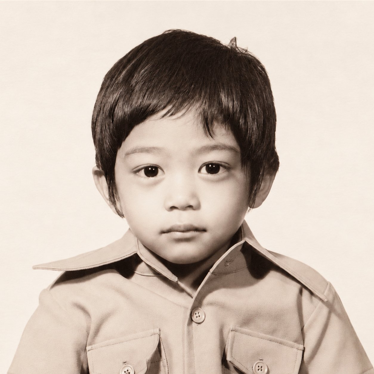 Sepia childhood studio portrait of Stephen Celestial, founder of MAIR Care Inc., as a young boy in a wide-collared shirt.