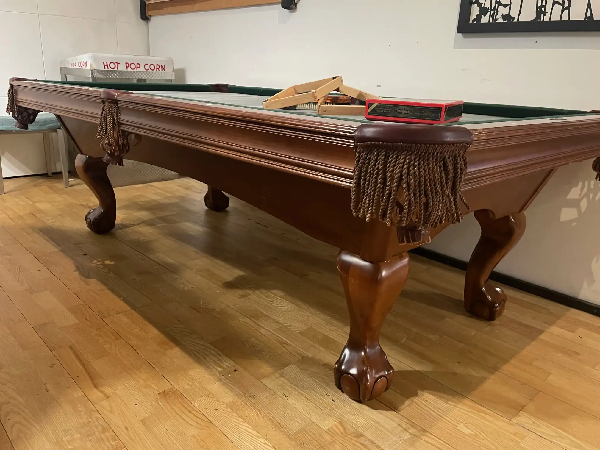 A classic Brunswick Bradford 8-foot pool table with cherry wood finish, ball and claw legs, and leather fringe pockets sits on a light hardwood floor.