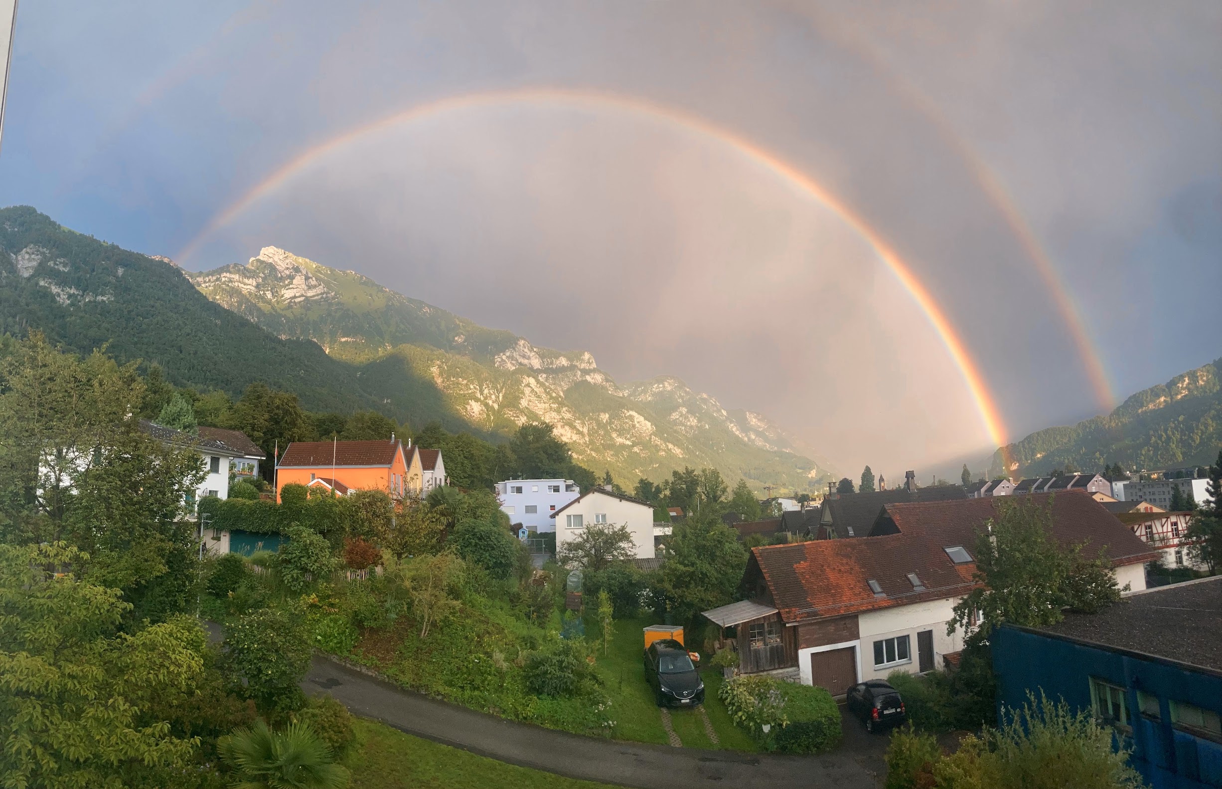 Double rainbow over a village at the foot of the mountains