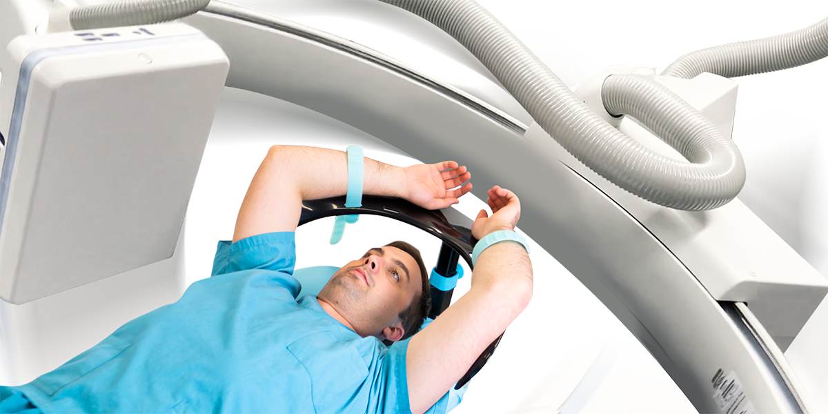 Adult male patient positioned with both arms overhead using the Adept Medical Overhead Arm Support MR Safe during imaging. Device fits through CT and MRI bores 700 mm or larger.