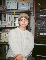 A person in a hat and glassesDescription automatically generated