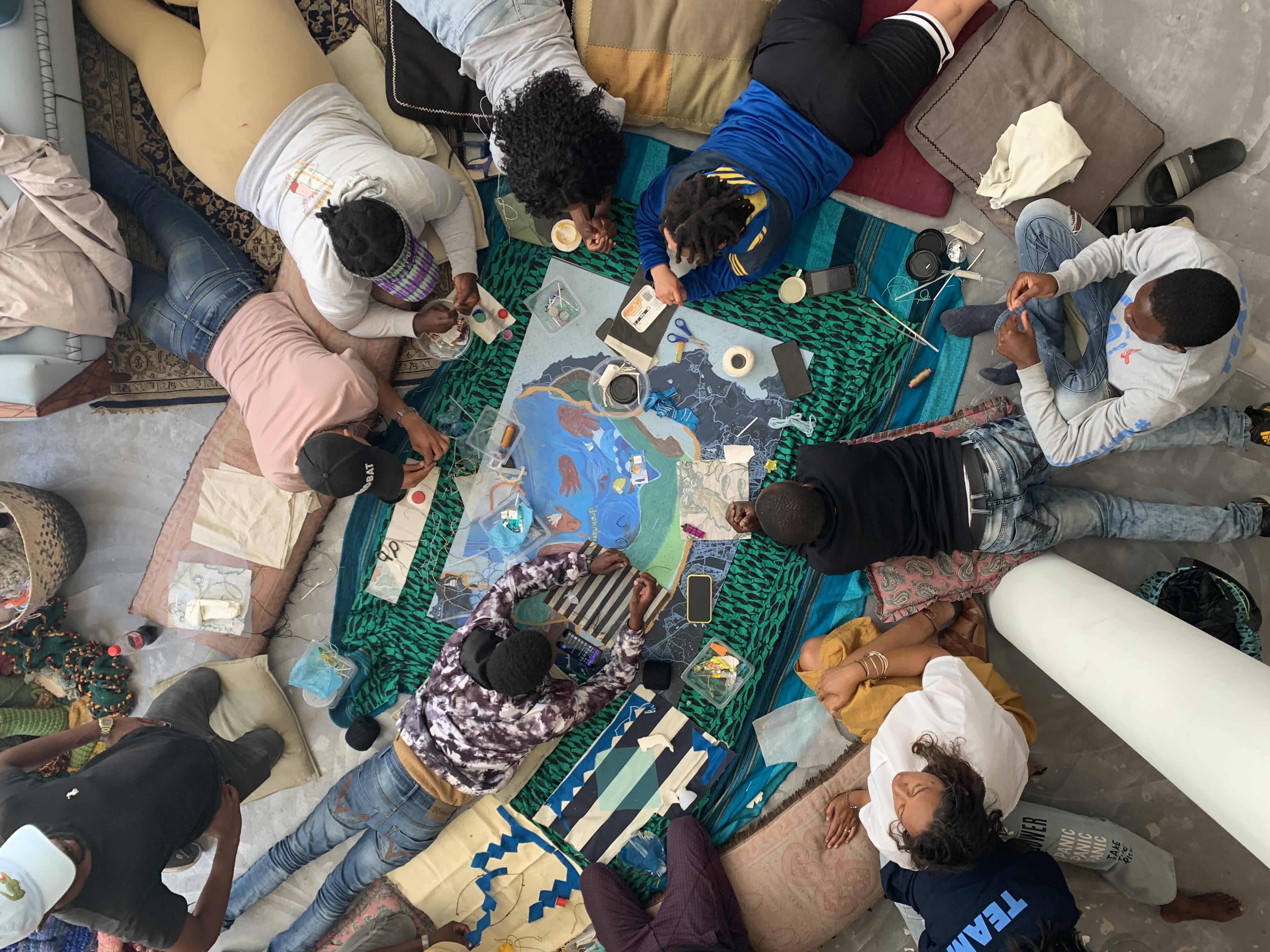 Hands working on the Mother Hydro-Rug, collectively, relationally, present.