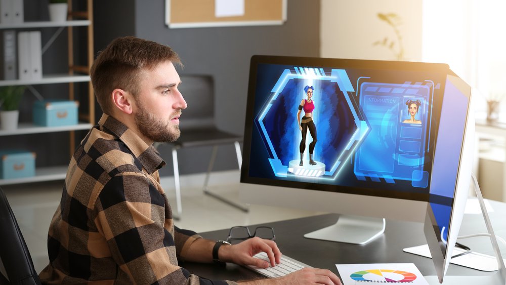 A man in flannel works on a desktop computer while creating a motion graphics video