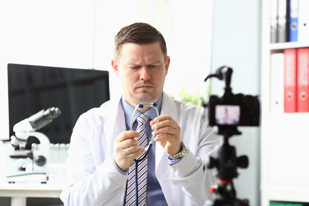 Doctor in a white coat filming a healthcare explainer video in a lab setting