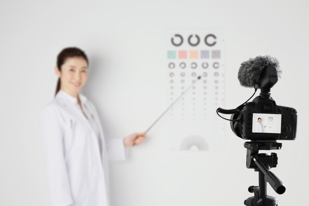 Healthcare professional recording a patient education video with a camera on a tripod