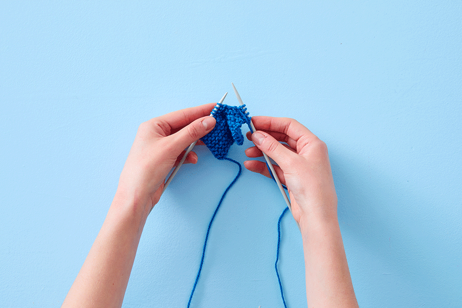A series of images demonstrating how to do a purl stitch. They show an overhead view of two hands using two grey knitting needles and blue yarn.