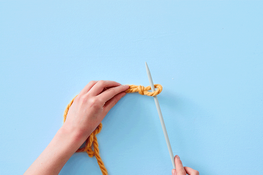 A series of images showing the first steps of creating a scarf. They show an overhead view of two hands using two grey knitting needles and chunky mustard-coloured yarn.